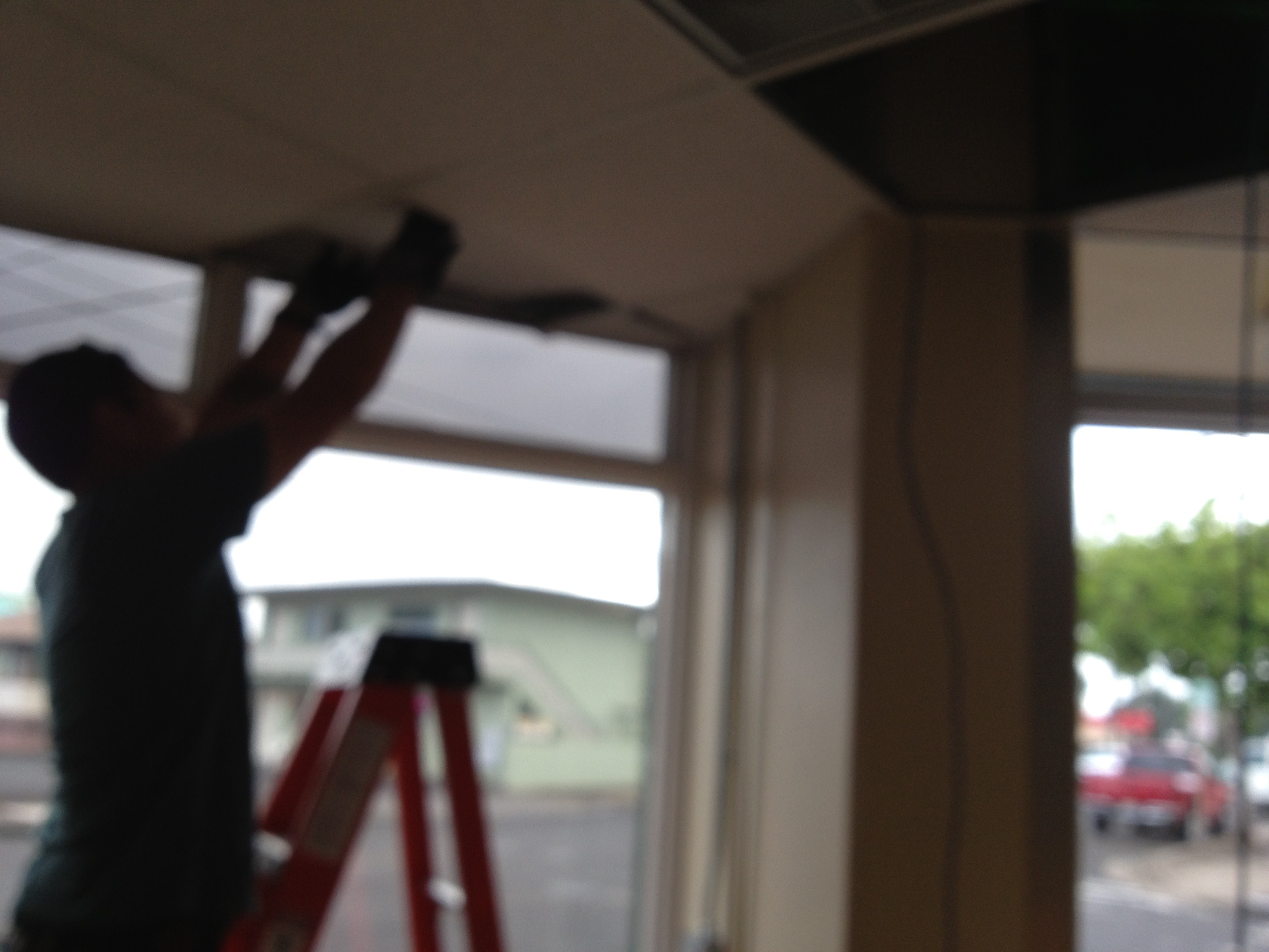 JM Electric electrician on ladder performing ceiling installation
