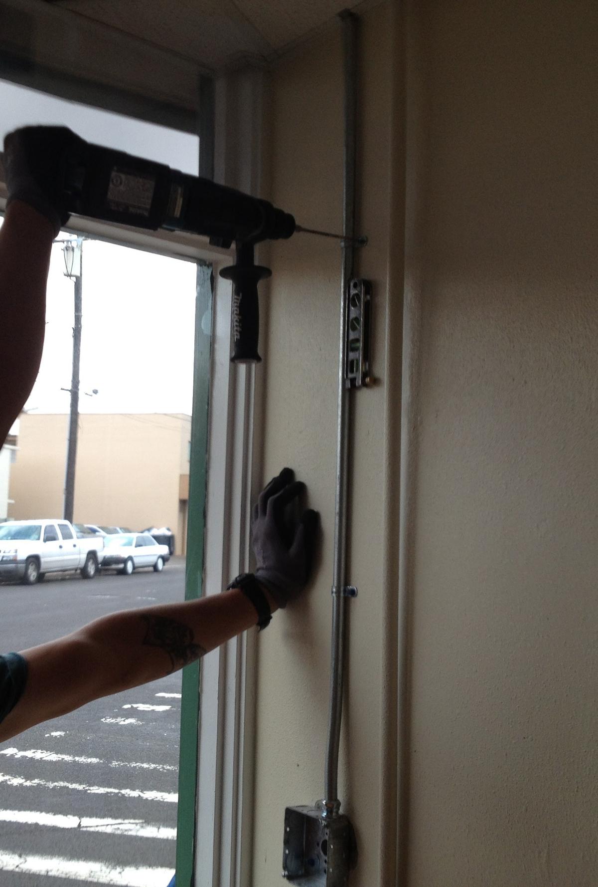 Electrician installing conduit on commercial building